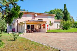 ein rosafarbenes Haus mit einer Terrasse davor in der Unterkunft Villa Li Cuponi in Arzachena