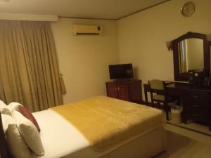 - une chambre avec un lit, un bureau et un miroir dans l'établissement Hotel Shalimar Rawalpindi, à Rawalpindi