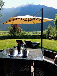 a table with an umbrella and two bottles of wine at Gurgltal Refugia in Tarrenz