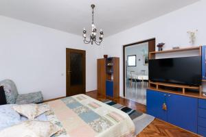 - une chambre avec une télévision et une commode bleue dans l'établissement Apartments Anka, à Rab