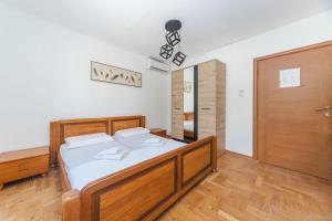 - une chambre avec un lit et une porte en bois dans l'établissement Guest House Zuber, à Budva