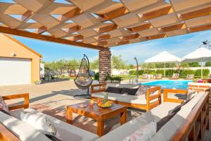 a patio with a couch and a table and a pool at House Leonardo in Galovac