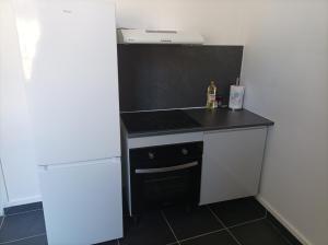 a kitchen with a stove top oven next to a refrigerator at O'Couvent - Appartement 79 m2 - 2 chambres - A512 in Salins-les-Bains