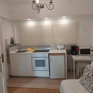 a small kitchen with white cabinets and a sink at APARTMANI RUŽICA in Crikvenica
