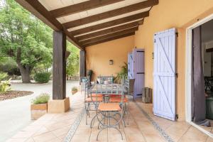 un patio con mesa y sillas y una puerta azul en Villa Laforge, en Carmona