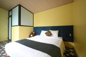 two beds in a room with yellow and blue walls at Catba Papillon Garden Bungalows & Resort in Cat Ba