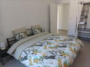 a bedroom with a bed with a colorful comforter at O'Couvent - Appartement 79 m2 - 2 chambres - A512 in Salins-les-Bains