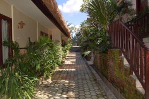 an alley with palm trees and a building at Swaloh Resort & Spa in Kalangbret