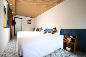 two beds in a room with white and blue at Catba Papillon Garden Bungalows & Resort in Cat Ba