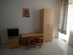 a room with a desk and a tv and a table and chairs at Despina in Nesebar