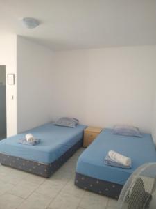 two beds in a room with blue sheets and towels at Despina in Nesebar