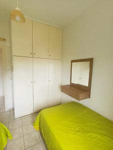 a bedroom with a green bed and a mirror at Cathrin Beach Apartments in Stavros