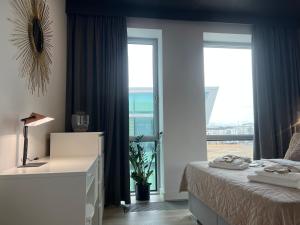 グディニャにあるModern Vero Apartments Yacht Parkのベッドと大きな窓のある寝室