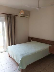 a bedroom with a bed in a room with a window at Cathrin Beach Apartments in Stavros