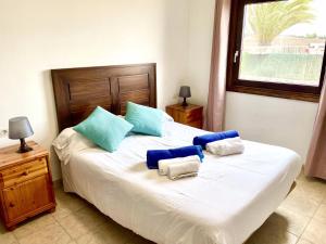 sypialnia z dużym łóżkiem z niebiesko-białymi poduszkami w obiekcie Villa 1B w mieście Playa Blanca