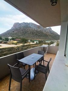 a table and chairs on a balcony with a mountain at Cathrin Beach Apartments in Stavros