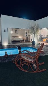 a swimming pool with a chaise lounge next to a swimming pool at شاليه الجبل in Ḑubā