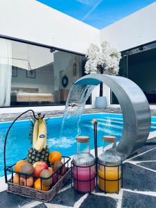 a fountain with fruit in baskets next to a swimming pool at شاليه الجبل in Ḑubā