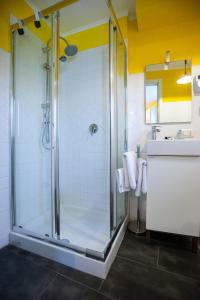a bathroom with a glass shower with a sink at Da Aurora al 27 in Manciano
