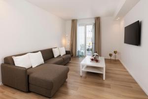 The Palm Riccione في ريتشيوني: غرفة معيشة بها أريكة وطاولة