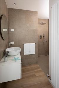W łazience znajduje się biała umywalka i lustro. w obiekcie The Palm Riccione w mieście Riccione
