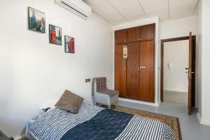 ein Schlafzimmer mit einem Bett und einem Stuhl darin in der Unterkunft Espace Zen in Temara