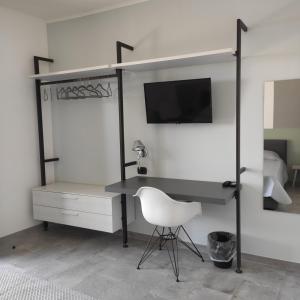 una camera da letto con scrivania, sedia e TV di Locanda Göghin a Pieve Ligure