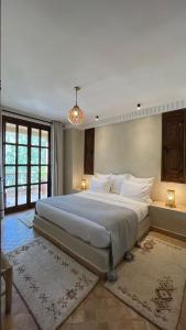 duża sypialnia z dużym łóżkiem z białą pościelą w obiekcie Chez Ichou w mieście Aït Idaïr