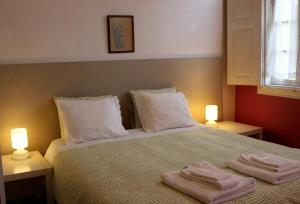 a bedroom with two towels on a bed with two lights at Casa de Encosturas in Cabeceiras de Basto +14 photos