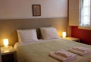 カベセイラス・デ・バストにあるCasa de Encosturasのベッドルーム1室(タオル2枚、ベッド1台、照明2つ付)