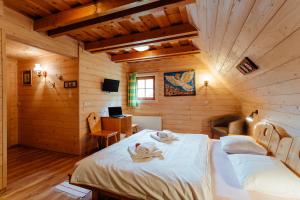 a bedroom with two beds in a wooden cabin at Wellness rezort Jánošíkov dvor in Zázrivá