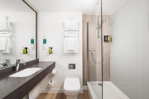 La salle de bains est pourvue de toilettes, d'un lavabo et d'une douche. dans l'établissement Holiday Inn Rochester-Chatham, an IHG Hotel, à Chatham
