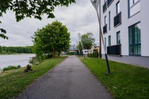 un camino junto a un edificio junto a un río en Vesiroosi Apartments - Apartment 3, en Pärnu