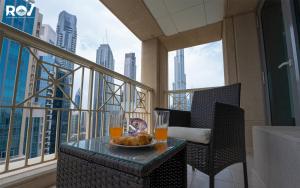a table with a plate of food on a balcony at Luxury 2 Bedroom Suite with Full Burj Khalifa View in Dubai