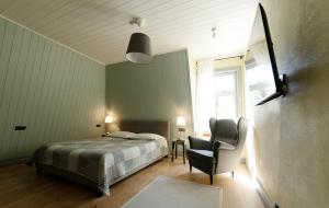 sypialnia z łóżkiem, krzesłem i oknem w obiekcie Verona Apartments w mieście Paide