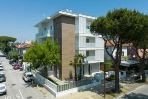 a building on a city street with trees and cars at The Palm Riccione in Riccione