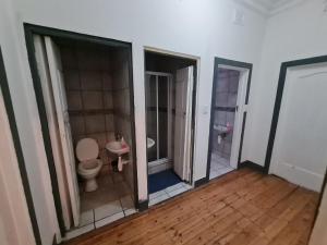 an empty bathroom with a toilet and a sink at Melville House in Johannesburg