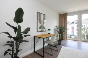 a living room with a table and a plant at 80qm Luxuriöse Designerwohnung im Herzen Bochums in Bochum