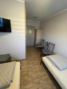 レシュノにあるWilla Leszczynkoのベッド2台、テーブル、椅子が備わる客室です。