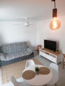 een woonkamer met een bank en een tafel bij summerland beach in Los Cristianos