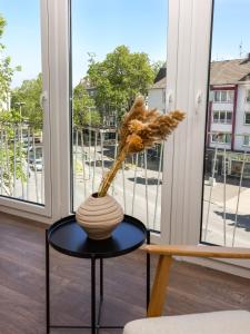 a vase on a table in front of a window at 80qm Luxuriöse Designerwohnung im Herzen Bochums in Bochum