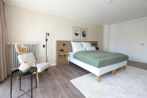 a bedroom with a bed and a chair at 80qm Luxuriöse Designerwohnung im Herzen Bochums in Bochum