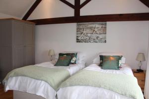two beds sitting next to each other in a bedroom at Peaceful and tranquil 2 bedroom Deer Cottage in Chippenham