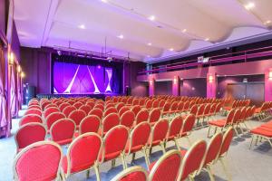 een leeg auditorium met rode stoelen en een podium bij Allegro Agadir in Agadir