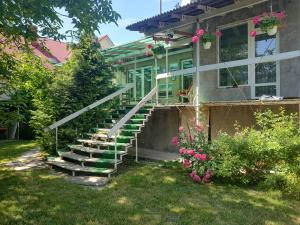 una casa con escaleras y flores en el patio en "Ранчо" - тераса квіти сад басейн, en Uzhhorod