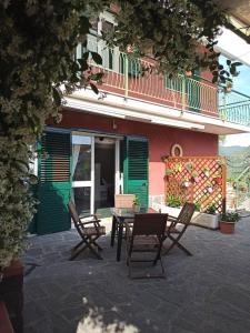 un patio con sillas y una mesa frente a un edificio en Il Glicine appartamento vacanze, non solo mare!, en Casarza Ligure