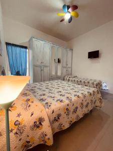 1 Schlafzimmer mit 2 Betten und einem Deckenventilator in der Unterkunft Appartamento - Rosamarina in Torre Colimena