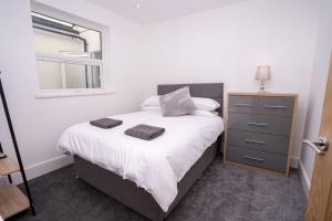 1 dormitorio con 1 cama con tocador y espejo en A Beautiful 2 Bedroom Apartment with outdoor space, en Blackpool