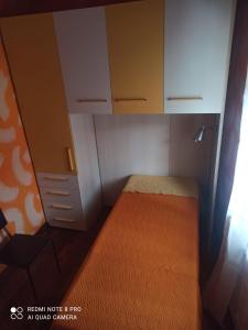 una piccola camera con letto e armadietti bianchi di sentieri 2 a Pecetto di Valenza