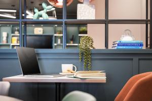 a laptop sitting on a table with a book at Holiday Inn Leeds-Wakefield M1 Jct40, an IHG Hotel in Wakefield